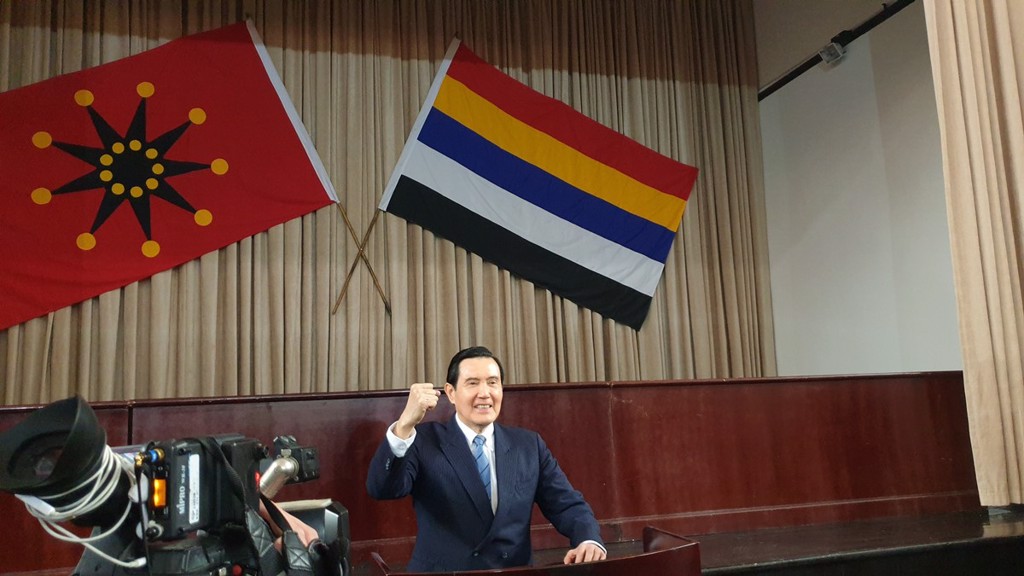 描述: 前總統馬英九30日上午在武漢參訪辛亥革命博物院，站在講台前模仿孫中山鄉音說「三民主義五權憲法」。後方兩面旗幟分別是武昌革命軍使用的九角十八星旗、南京上海軍政府用的五色旗，象徵漢滿蒙回藏五族共和。（藍孝威攝）